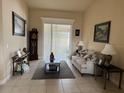 Inviting living room with neutral paint, tile floors, comfortable sofa, and views to the outdoor space at 2663 Brookside Bluff Loop, Lakeland, FL 33813