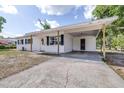 Charming single-story home with a spacious driveway, covered carport, and a classic white exterior at 280 W Pierce St, Lake Alfred, FL 33850