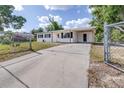 Charming single-story house featuring a fenced yard, spacious driveway, and covered carport at 280 W Pierce St, Lake Alfred, FL 33850