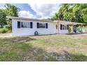 Charming single-story home featuring a classic white exterior, black shutters, and well-maintained lawn at 280 W Pierce St, Lake Alfred, FL 33850