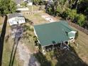 This aerial view showcases the home's green metal roof, a detached garage, and ample parking space at 3233 Gardner Rd, Lakeland, FL 33810