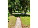 Inviting front yard features a sidewalk leading to the home with mature trees creating a shady canopy at 375 Westover Pkwy, Bartow, FL 33830