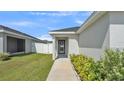Inviting front entrance with a decorative wreath, a well-maintained lawn, and lush landscaping at 3946 Willow Ridge Dr, Lakeland, FL 33810