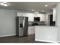 New kitchen with stainless steel appliances, white cabinets, and laminate floors at 4038 Oak Loop # 103, Mulberry, FL 33860