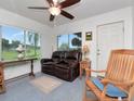Cozy living room with a ceiling fan, large windows, and a comfortable leather sofa at 427 Longfellow Blvd, Lakeland, FL 33801