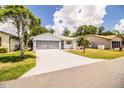 Inviting home showcasing a spacious driveway leading to a two-car garage and a charming, landscaped front yard at 4976 Pleasant Hollow Trl, Lakeland, FL 33811