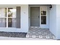 Inviting front entrance featuring stylish tile steps, gray door with sidelight window, and decorative shutter at 502 Duchess Dr, Lakeland, FL 33803