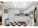 Classic kitchen with white cabinets, appliances, and checkerboard flooring at 512 Cameo Dr, Lakeland, FL 33803