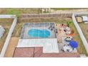 Aerial view of a home with fenced backyard featuring a screened-in pool and outdoor dining area at 5246 Montserrat Dr, Lakeland, FL 33812