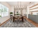 Well-lit dining room with modern chandelier, hardwood floors, and view of the kitchen at 527 W Park St, Lakeland, FL 33803