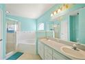 Bright bathroom featuring double sinks, a large mirror, a soaking tub, and a separate glass-enclosed shower at 603 Reflections Loop, Winter Haven, FL 33884