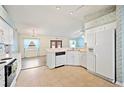 Well-lit kitchen featuring white cabinets, modern appliances, and a functional layout, seamlessly connected to the dining area at 603 Reflections Loop, Winter Haven, FL 33884