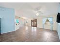 Spacious living room with tile flooring, ceiling fan, and natural light streaming through the windows and double doors at 603 Reflections Loop, Winter Haven, FL 33884