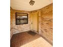 Enclosed front porch featuring brick walls, a window, and a secure front door entrance at 668 Jamaica Cir, Lakeland, FL 33803