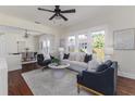 Bright living room with large windows, modern furnishings, and hardwood floors. Dining room in background at 737 Johnson Ave, Lakeland, FL 33801