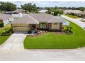 Well-maintained single-story home featuring lush green lawn, attractive landscaping, and a paved driveway at 7890 Ashford Dr, Lakeland, FL 33810