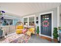 Cozy front porch featuring egg chairs, a colorful rug, and a black front door at 807 Osceola St, Lakeland, FL 33801