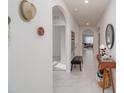Bright hallway featuring stylish decor, arched doorways, and tile flooring at 860 Killarney Ln, Auburndale, FL 33823