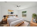 Bright bedroom features a large window, neutral walls, ceiling fan and wood-look laminate flooring at 950 W 2Nd St, Lakeland, FL 33805
