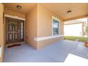 Inviting front porch with a decorative door and sidelight, perfect for enjoying the outdoors at 983 Revere Ave, Haines City, FL 33844