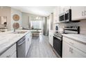 Modern kitchen featuring granite counters, stainless appliances, gray tile flooring and dining nook at 1067 Aruba Ave, Mulberry, FL 33860