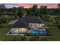 Aerial view of home with screened pool, fenced yard, mature trees and lush greenery at 130 Sylvana Ct, Auburndale, FL 33823