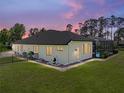 Rear exterior view of home showing fenced yard and screened pool enclosure at 130 Sylvana Ct, Auburndale, FL 33823