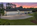 Rear exterior view of home showing large driveway and three-car garage at 130 Sylvana Ct, Auburndale, FL 33823