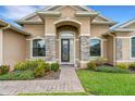 Charming front entrance with stone accents and a well-manicured garden at 1470 Silver Leaf Dr, Lakeland, FL 33813