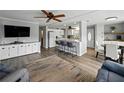 Bright living room with hardwood floors, ceiling fan, TV, and a large window to the outside at 1642 Tally Ho Dr, Lakeland, FL 33810