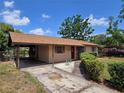 Exterior shot showing the driveway, carport, and attractive front entrance of this appealing home at 1809 Optimist Dr, Lakeland, FL 33801