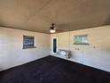 Enclosed porch with concrete flooring, ceiling fan, and swing; creating a cozy outdoor space at 1809 Optimist Dr, Lakeland, FL 33801
