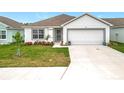Inviting single-story home features a well-maintained lawn and a two-car garage at 1821 Thompson Preserve Boulevard, Bartow, FL 33830