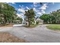 Long driveway leading to a charming home, surrounded by lush greenery and mature trees at 2070 W Lake Hamilton Dr, Winter Haven, FL 33881