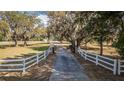 Long driveway to the property with a white fence lining the entrance, providing a sense of privacy at 2070 W Lake Hamilton Dr, Winter Haven, FL 33881