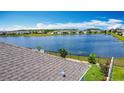 Lakeside backyard features a fence, green lawn, and mature landscaping at 2318 Rush Bay Way, Orlando, FL 32824