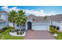Inviting single-story home with palm trees, brick driveway, and well-manicured lawn at 2318 Rush Bay Way, Orlando, FL 32824