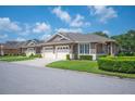 Charming single-story home features a well-manicured lawn and attached two-car garage at 2965 Mission Lakes Dr, Lakeland, FL 33803
