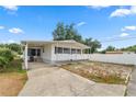 Charming single-story home with covered parking and a partially fenced yard on a sunny day at 3027 Mimosa Way, Lakeland, FL 33801