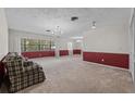 Spacious living room featuring plush carpeting, natural light, and a decorative chandelier lighting fixture at 3441 Sherertz Rd, Lakeland, FL 33810