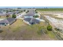 Aerial view of the home showcasing its backyard, solar panels, and neighboring houses and landscape at 3560 Spring Creek Rd, Dundee, FL 33838