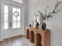 Chic entryway with wood-look tile flooring, white front door and decorative table with rounded wooden base at 3664 Frentress Dr, Lakeland, FL 33812