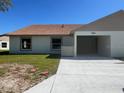 New construction single-story duplex featuring a carport, neutral paint, and a well-maintained lawn at 4056 Oak Loop # 100, Mulberry, FL 33860