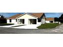 View of a home with attached garages, concrete driveway, and green lawn at 4058 Oak Loop # 99, Mulberry, FL 33860