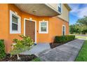Inviting front entry with neatly trimmed bushes and flowers surrounding the concrete walkway at 4078 Winding Vine Dr, Lakeland, FL 33812
