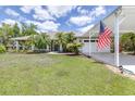 Single-story home with a lush green lawn, side-entry garage and well maintained landscaping at 4540 Park Ave, Indian Lake Estates, FL 33855