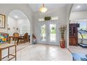 Grand foyer with tile flooring, arched doorways, and elegant glass paneled double doors at 4540 Park Ave, Indian Lake Estates, FL 33855