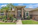 Inviting front entrance with brick pillars, lush landscaping, and a welcoming pathway leading to the front door at 4965 Tradition Dr, Lakeland, FL 33812