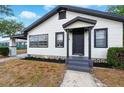 Inviting home with fresh landscaping, covered entry, and appealing white and dark gray color scheme at 522 Channing Rd, Lakeland, FL 33805