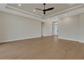 Bright living room with tray ceiling, ceiling fan, recessed lights, and wood-look flooring at 5390 Clubhouse Hills Ln, Lakeland, FL 33812